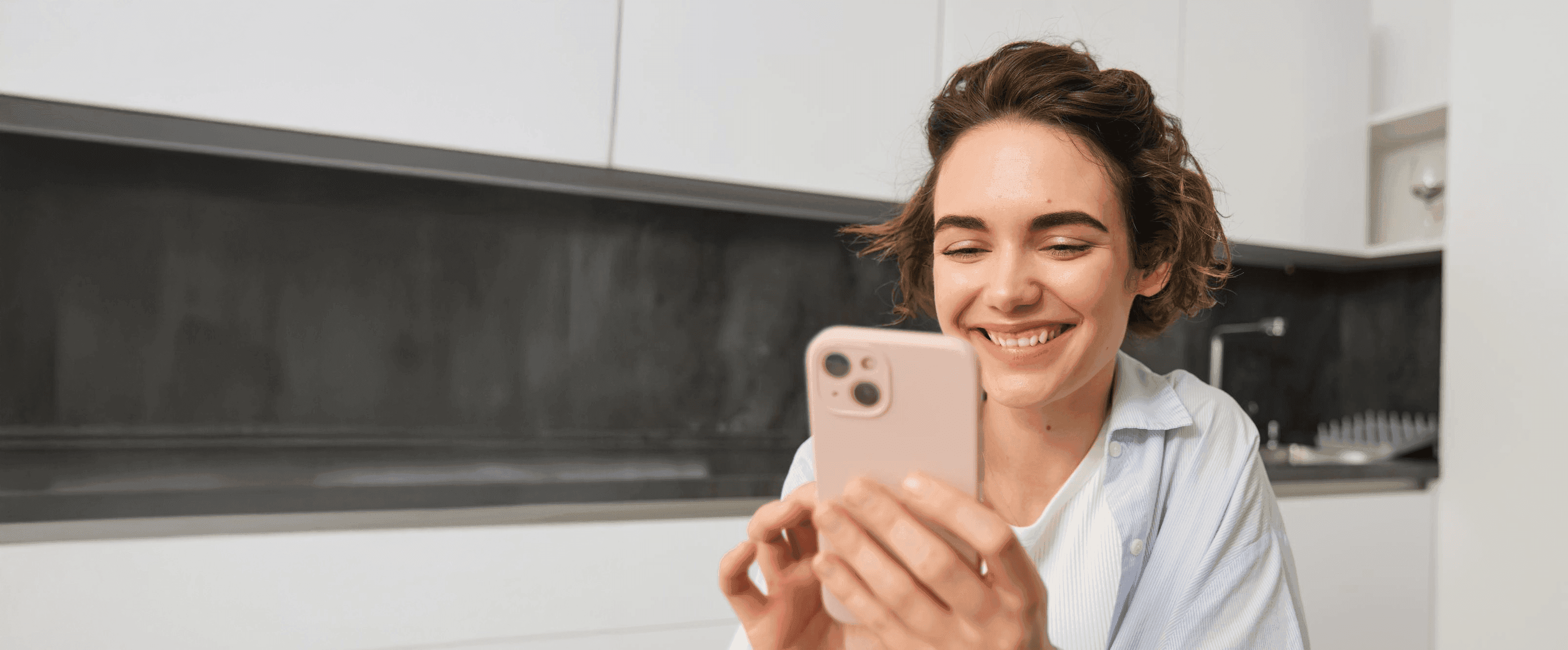 Mulher sorrindo utilizando smartphone com histórico unificado Meu AVIZO